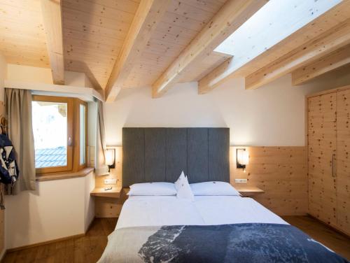 a bedroom with a large bed and a window at Familienhotel Huber in Valles