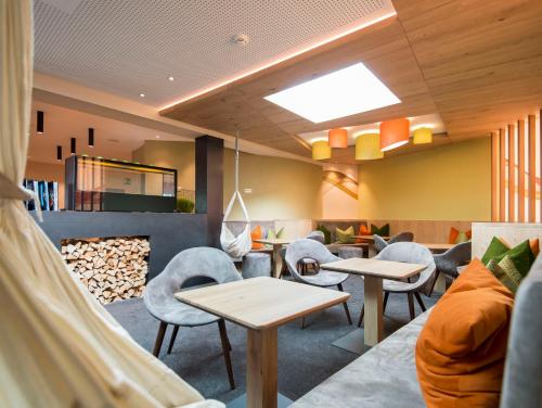 a restaurant with tables and chairs and a fireplace at Familienhotel Huber in Valles