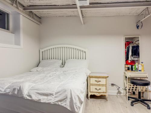 a white bedroom with a bed and a chair at Comfort West Urban Chicago loft house in Chicago