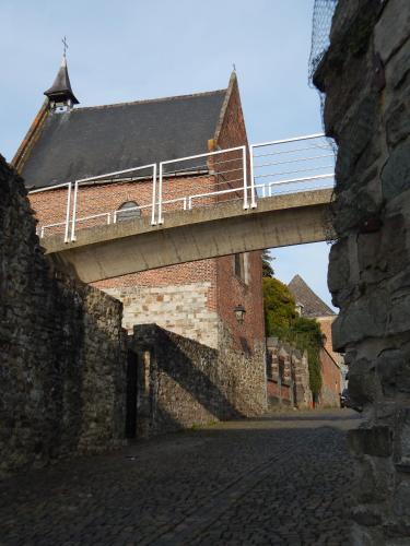 a bridge over a brick street with a building at Les Remparts in Binche