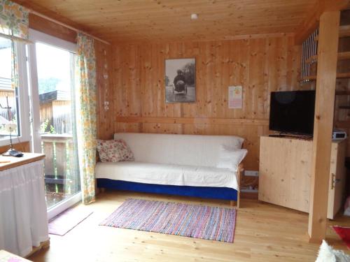 a bedroom with a bed in a wooden wall at Feriendorf Tauerngast in Hohentauern