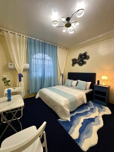 a bedroom with a bed and a table and chairs at Carmela Haven Inn in Baler