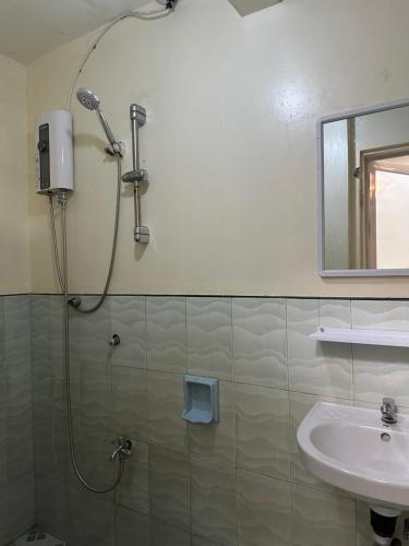 a bathroom with a shower and a sink at Carmela Haven Inn in Baler