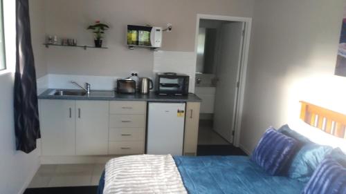 a small kitchen with a bed and a sink at Stream View in Christchurch