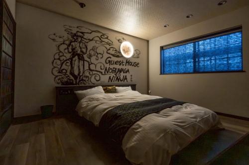 a bedroom with a bed with a sign on the wall at 旅宿信長と忍者---2階-忍者の間---NOBUNAGAtoNINJA in Omihachiman