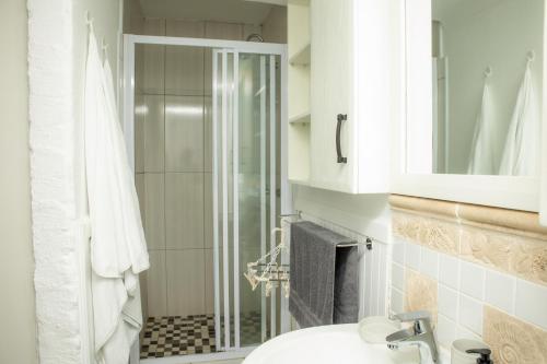 a bathroom with a shower and a sink and a toilet at Black n Whyt Villa in Kloof