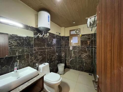 a bathroom with a white toilet and a sink at The Summerlead, Shimla in Shimla