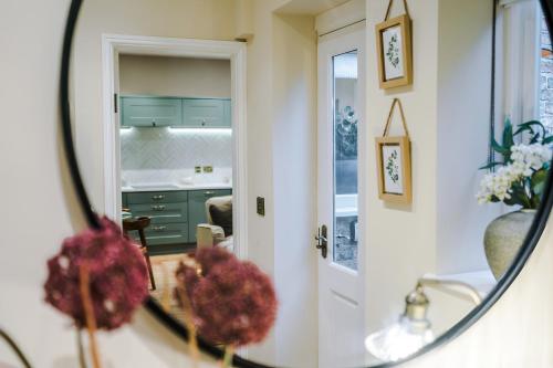 a bathroom mirror with a sink and a kitchen at Cathedral Mews - Close to the Cathedral in Ripon