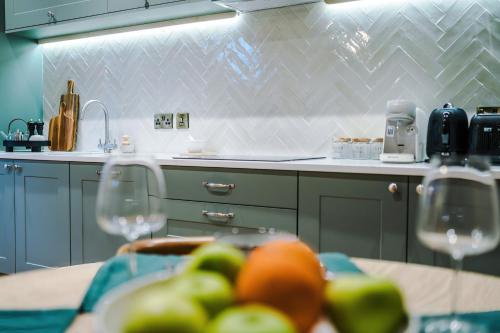 a kitchen with a table with two wine glasses at Cathedral Mews - Close to the Cathedral in Ripon