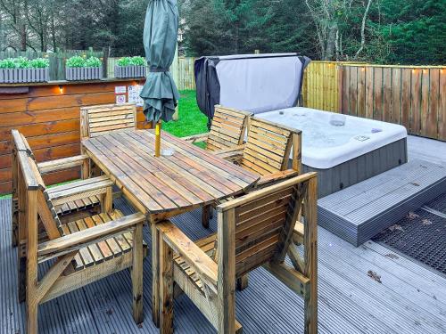 a wooden table and chairs with an umbrella on a deck at The Outback - Uk50982 in West Thirston