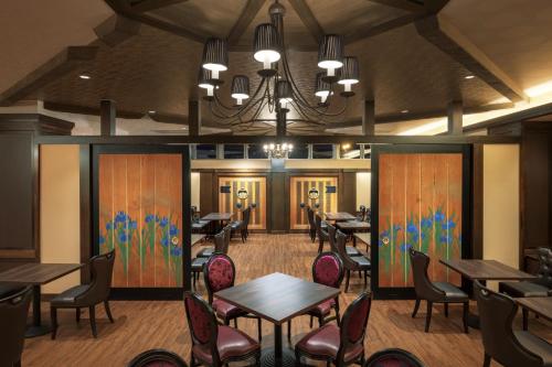 a restaurant with tables and chairs and a chandelier at Hotel Grand Mer Sankaiso in Ajigasawa