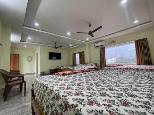 a bedroom with a large bed with a large window at Amaravathi Residency in Nārāyanavanam