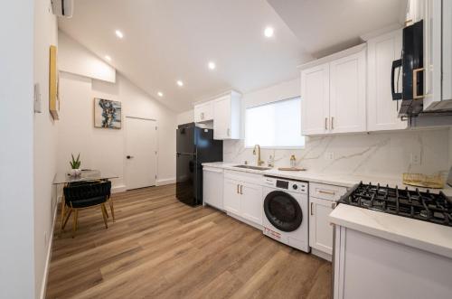 a kitchen with white cabinets and a washer at Stellar Sherman Oaks One Bedroom close to Universal Studios in Burbank