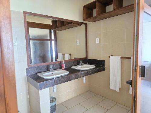 a bathroom with two sinks and a mirror at Chic two bedroom Beachfront apartment 5th floor in Ukunda