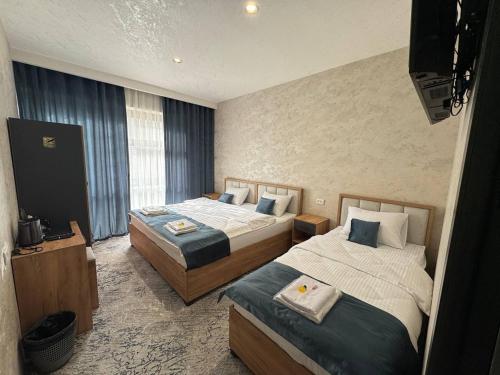 a hotel room with two beds and a television at Best Guest House in Andizhan