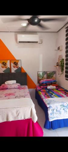 a room with two beds and a ceiling at KAMI roomstay 2 in Kampong Banggol Lalang