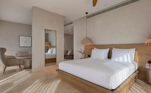ein Schlafzimmer mit einem weißen Bett und ein Wohnzimmer in der Unterkunft Isla Brown Eilat in Eilat