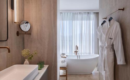 ein Badezimmer mit einer weißen Badewanne und einem Waschbecken in der Unterkunft Isla Brown Eilat in Eilat