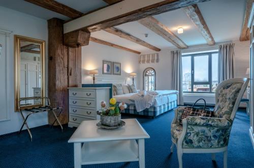 a bedroom with a bed and a table and a chair at Hotel Alter Kornspeicher in Neustrelitz