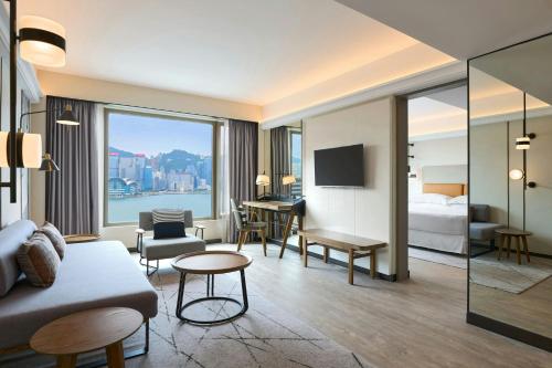 a hotel room with a bed and a living room at Sheraton Hong Kong Hotel & Towers in Hong Kong