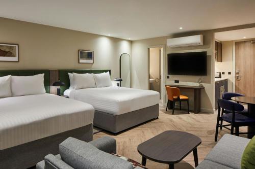 a hotel room with two beds and a desk at Residence Inn by Marriott Edinburgh in Edinburgh