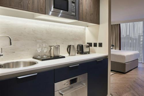 a kitchen with a sink and a microwave at Residence Inn by Marriott Edinburgh in Edinburgh