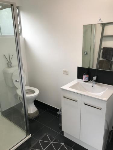 a bathroom with a white sink and a toilet at The Seaside Studio Retreat in Wye River