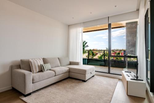 a living room with a couch and a large window at Winx Trackside Moonee Ponds in Moonee Ponds