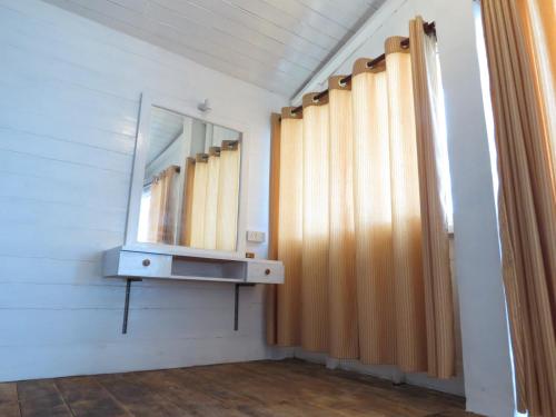 a bathroom with a sink and a mirror and curtains at Why Not Guest house in Hikkaduwa