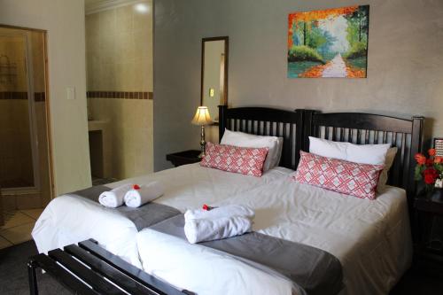 a bedroom with a large bed with pillows on it at 3 Liebeloft Guest House in Edenvale