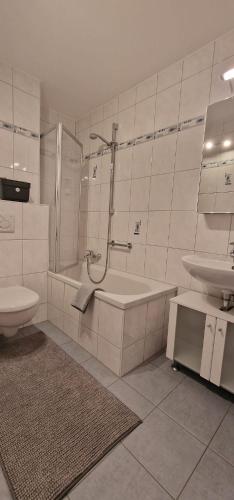 a bathroom with a tub and a toilet and a sink at Boxspring Apartment Rottweil mit Stellplatz in Rottweil