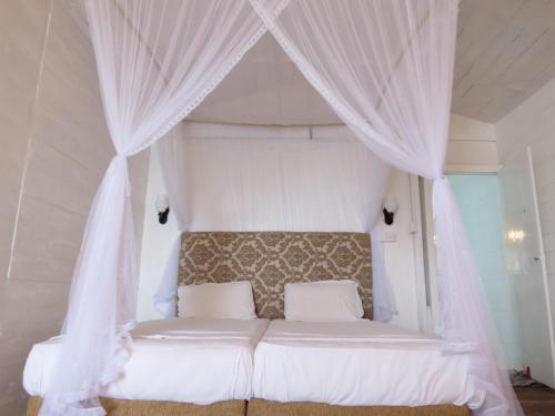 a bedroom with a bed with a canopy at Why Not Guest house in Hikkaduwa