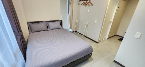 a bed with two pillows in a room at KIYAZA Resort 沖縄 KUME in Naha