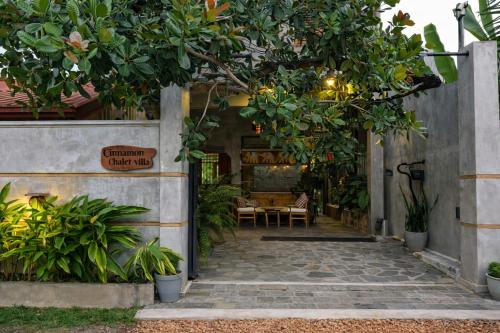 an entrance to a house with a large tree overhead at Cinnamon Villas in Ambalangoda