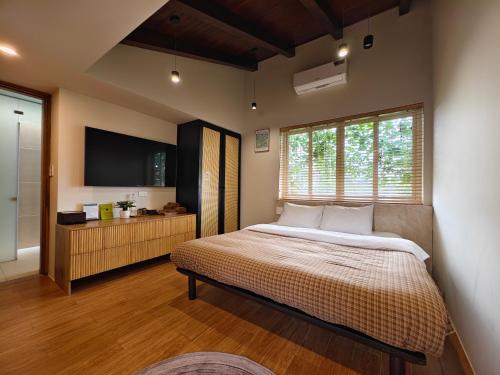 a bedroom with a large bed and a television at Ansora Homestay Huế in Thôn An Hòa