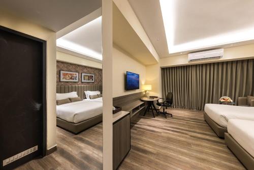 a hotel room with two beds and a desk at SureStay by Best Western in Cox's Bazar