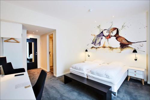 a bedroom with a bed with a painting on the wall at Hotel Hafnia in Tórshavn
