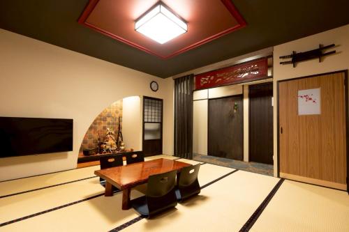 a dining room with a wooden table and a tv at 旅宿信長と忍者---1階-信長の間---NOBUNAGAtoNINJA in Omihachiman