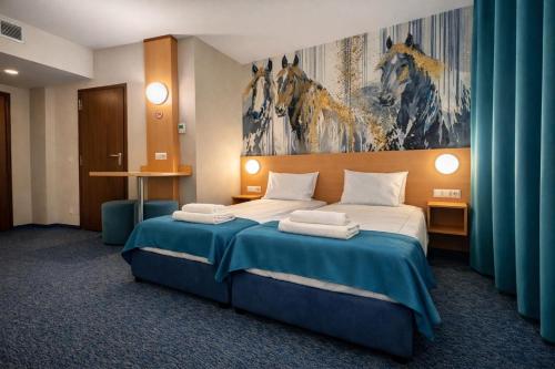 a hotel room with a bed with a painting on the wall at WESTGATE Hotel - FREE PARKING in Veliko Tŭrnovo