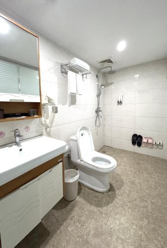 a bathroom with a toilet and a sink and a mirror at 枳兮酒店 渝中区解放碑 in Chongqing