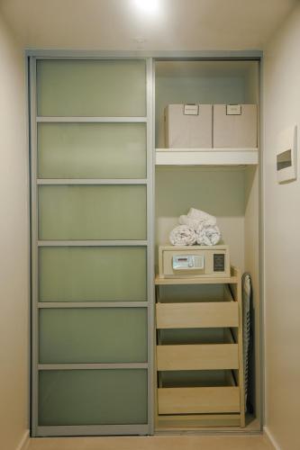 a walk in closet with shelves and a microwave at Darwin Central Escape Hotel Style Apartment with Kitchen , Pool , Gym , Car Park,Balconey in Darwin