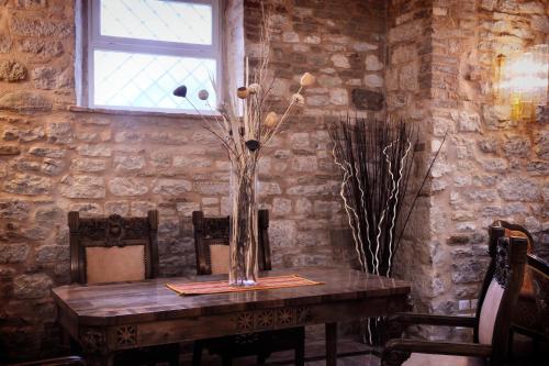 a dining room with a table with a vase on it at Hotel San Marco in Gubbio