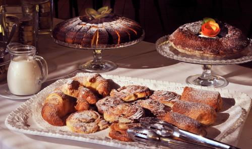 a table with two trays of pastries and other desserts at Hotel San Marco in Gubbio