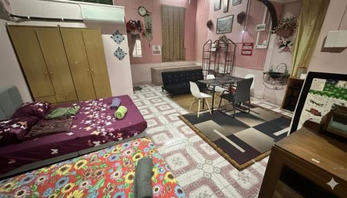 a living room with a bed and a table in it at Iltizam Guest House in Kuala Berang
