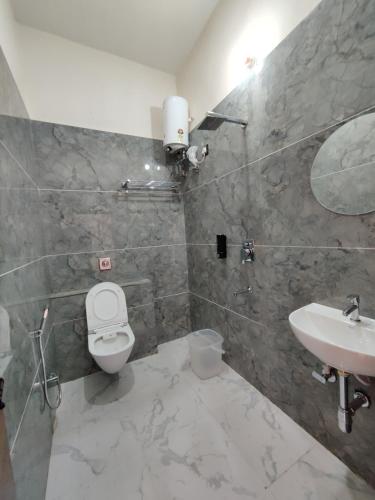 a bathroom with a toilet and a sink at Hotel Ekana in Chhatarpur