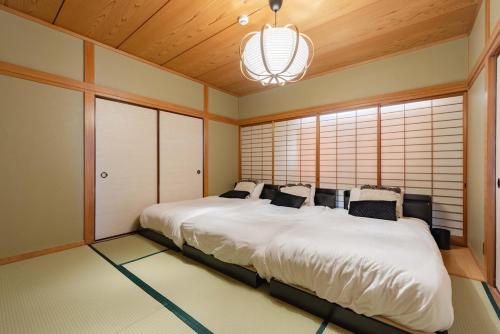 a large white bed in a room with windows at LINKAGE STAY Chitose Funabashi in Tokyo