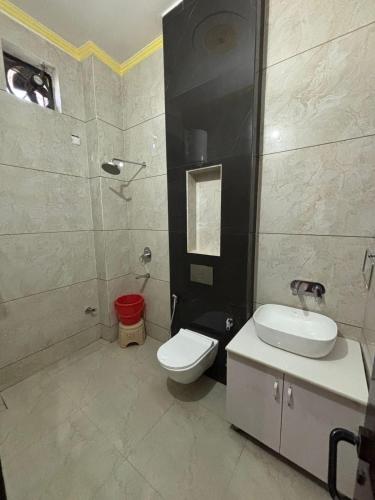 a bathroom with a white toilet and a sink at Primrose Hotel in Murthal