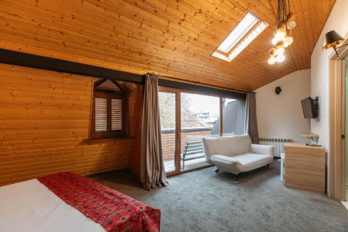 a bedroom with a bed and a chair and a window at Tekla Palace By Urban Hotels in Tbilisi City