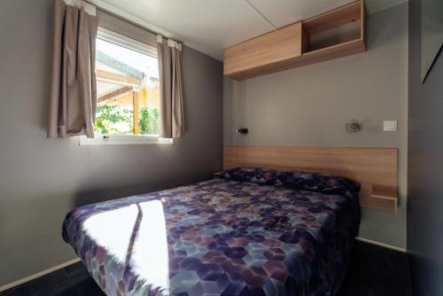 a bedroom with a bed in a room with a window at Camping El Pasqualet in Caldes de Montbui