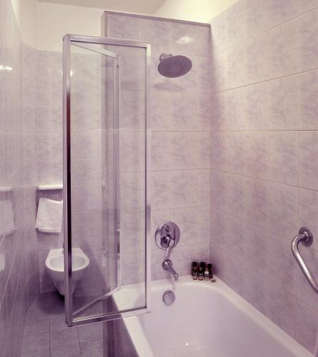 a bathroom with a shower and a tub and a toilet at Hotel San Marco in Gubbio